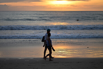 Naklejka premium A young couple walking on the beach of Phuket-Thailand in the sunset.