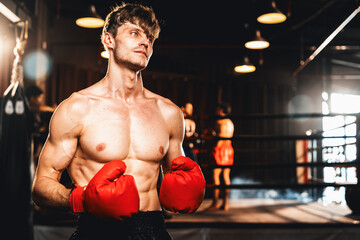 Boxing fighter shirtless posing, caucasian man boxer wearing red glove in defensive guard stance...
