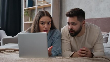 Caucasian upset couple husband wife worried shocked disappointed bad news loss negative result breakdown laptop internet service displeased woman girl and man guy in bedroom computer addicted failure - Powered by Adobe