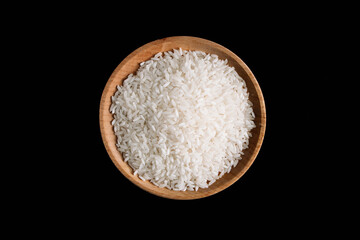 Fototapeta na wymiar Raw white rice on black background. Long uncooked rice in wooden plate.