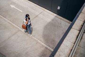 Young Japanese woman reading a message on the mobile phone in the city

