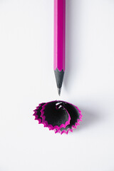 Wooden purple pencil and shavings on white background.