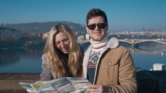 Young couple tourists examining the map of Prague. Tourism, travel, friendship, love, concept. Filmed on REd 4k, 10 bit color