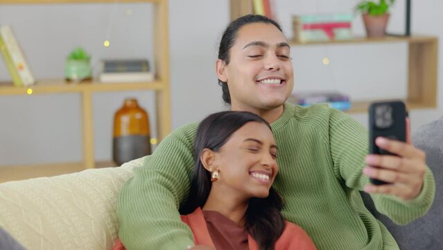 Couple, selfie and happy, bonding with love and relax on couch, interracial with trust and support in relationship. Young people at home together, smile and posing in picture for social media post