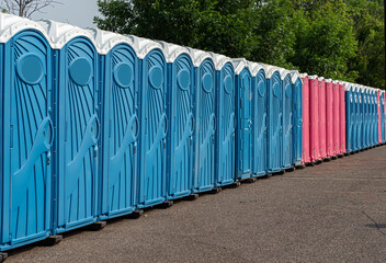 a row of colorful blue and pink portable toilets