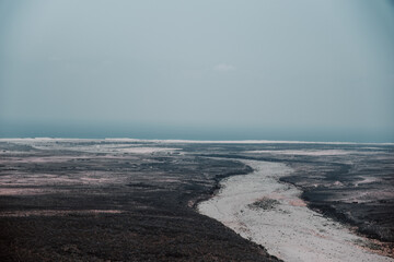 Aerial view of dry riverbed winding through coastal plain in Socotra, Yemen.

