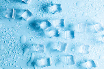 Ice cube background. Flat lay top view of Ice cubes with water drops scattered on blue background. Ice concept for drinks