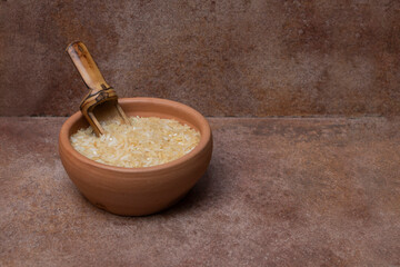 Ceramic pot with wooden spoon and white rice