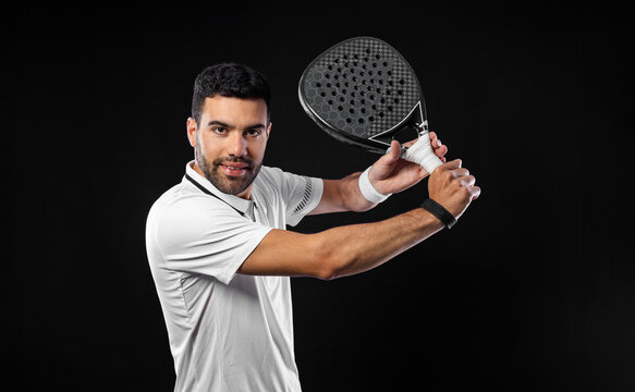 Padel tennis player with racket. Man athlete with paddle racket on black background. Sport concept. Download a high quality photo for sports website.