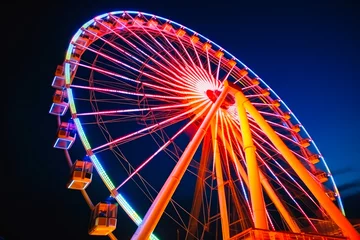 Deurstickers Ferris wheel ride glowing in the dark in an amusement park, fairground rides on outdoor area, entertainment activity. Generative AI © MVProductions