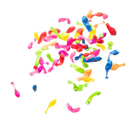Deflated rubber colorful balloons fly in air. Many colorful deflated balloons in red, blue, yellow throw scatter. Toy for kid to play in birthday party and celebrate, white background isolated