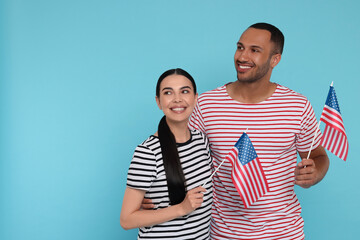 Obraz premium 4th of July - Independence Day of USA. Happy couple with American flags on light blue background, space for text