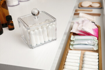 Fototapeta na wymiar Many different feminine hygiene products on white chest of drawers