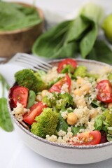 Healthy meal. Tasty salad with quinoa, chickpeas and vegetables served on white table, closeup