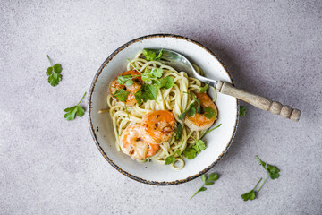 Several portions of cooked and twisted Spaghetti pasta with king prawn tails