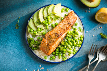 Poke bowl with rice, salmon,avocado and peas, sesame seeds on blue background