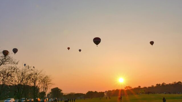 .Chiang Rai,Thailand - February 18,2018:sweet sunrise on the back of .colorful hot air balloons festival at Singha Park in Chiang Rai. .scenery sunrise flying colorful ballon background..