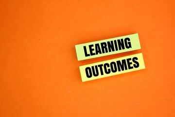 colored paper with the words Learning outcomes. learning concept. the concept of income from learning