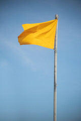 windy day weather, beach day, yellow warning flag, swim conditions, ocean safety caution flag for conditions of the water and waves