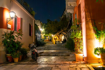 An illuminated sidewalk cafe in the Anafiotika neighborhood of the Plaka, underneath Acropolis Hill in the historic center of Athens, Greece.