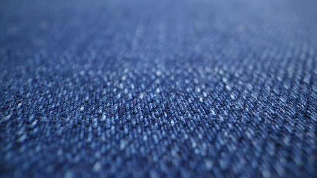 The structure of the fabric. Close-up of blue denim fabric. Dolly shot
