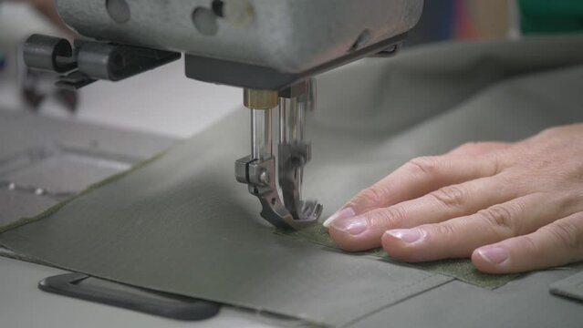 This stock video shows the hands of a seamstress who sews on a sewing machine. This video will decorate your projects related to sewing, seamstresses, light industry, seamstress profession.
