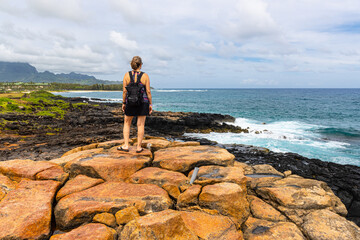 Female Hiker Looking Over The Volcanic Shoreline of Keoneloa Bay, Keoneloa Bay Trail, Poipu, Koloa, Kauai, Hawaii, USA