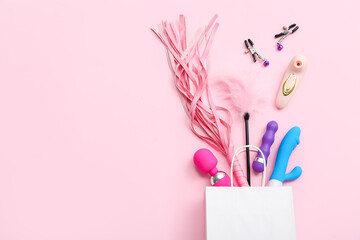 Shopping bag with sex toys on pink background - obrazy, fototapety, plakaty