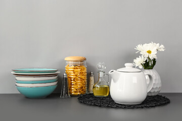Composition with teapot and different kitchen stuff on black table