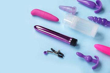Bottle of lubricant and sex toys on blue background