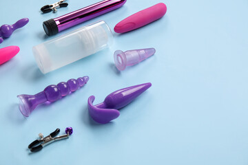 Bottle of lubricant and sex toys on blue background