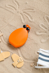 Fototapeta na wymiar Creative composition with sunscreen cream and beach accessories on sand
