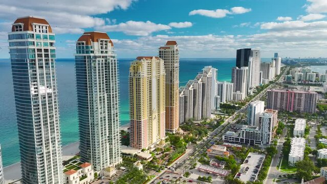 View from above of luxurious highrise hotels and condos on Atlantic ocean shore in Sunny Isles Beach city. Urban street with busy traffic. American tourism infrastructure in southern Florida
