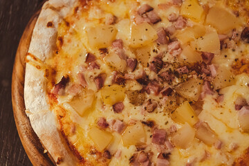 Close up of tasty and delicious thin hawaiian pizza with ham and pineapple