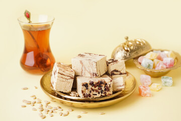 Plates with pieces of tasty marble halva on yellow background