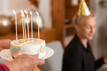 Mature man with birthday cake at party, closeup