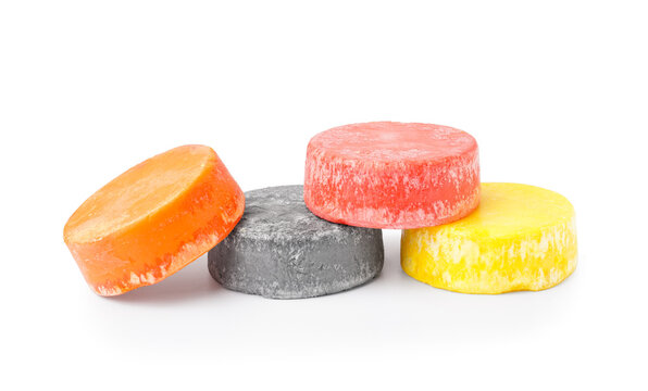 Colorful solid shampoo bars on white background
