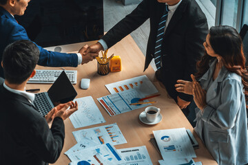 Group business people handshake at meeting table in office together with confident shot from top...