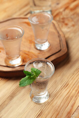 Glasses of cold vodka on wooden background