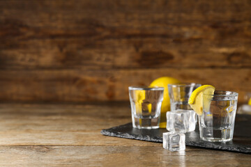 Glasses of cold vodka on wooden background