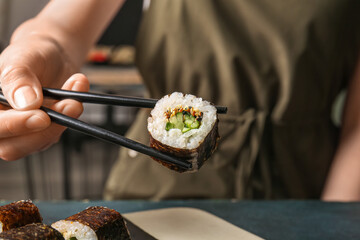 Woman eating tasty maki roll, closeup view © Pixel-Shot