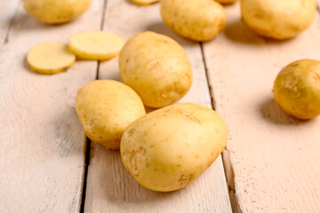 Raw baby potatoes on white wooden background