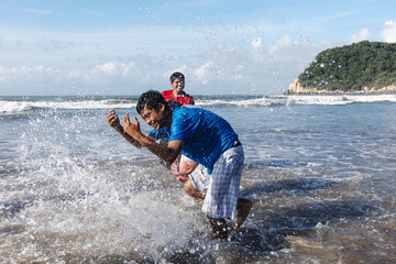 Happy latin friends teenagers at beach party runs and jumping to pacific ocean in Acapulco Mexico...