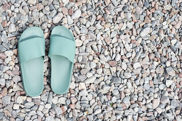 Turquoise flip-flops on rocky beach