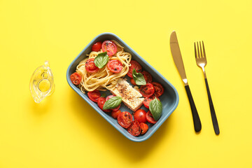 Fototapeta na wymiar Baking dish of tasty pasta with tomatoes and feta cheese on yellow background