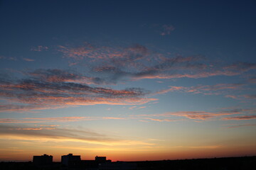 The sky and clouds at sunset on the background of the city line