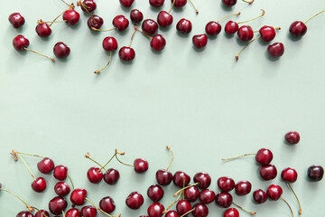 Many sweet cherries on green background