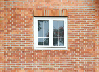Classic white windows on brick wall facade.