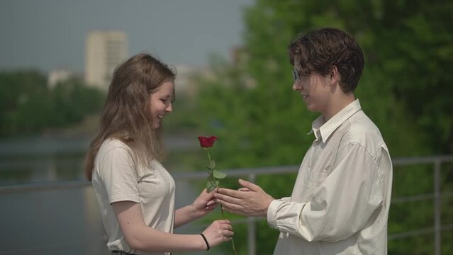 first relationship. teen date. a teenage boy gives a teenage girl a rose. slow motion video. High quality Full HD video recording
