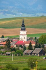 Old village with a tower, gardens and cultivated fields below the hills. Partizanska Lupca, near Liptovsky Mikulas, Liptov region, Slovakia